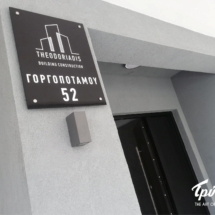 Ταμπελάκι από διάφανο plexiglass και εκτύπωση από την πίσω πλευρά δίνοντας την αίσθηση του καθρεφτίσματος με αποστάτες. Θεσσαλονίκη THEODORIADIS | ΕΠΙΓΡΑΦΗ PLEXIGLASS